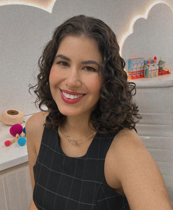 Dra. Bárbara Naves no consultório, com iluminação suave ao fundo